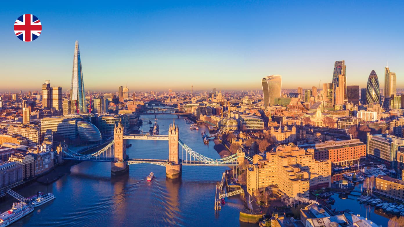 Aerial view of the London skyline with Tower Bridge over the River Thames, featuring The Shard during golden hour.​​ 