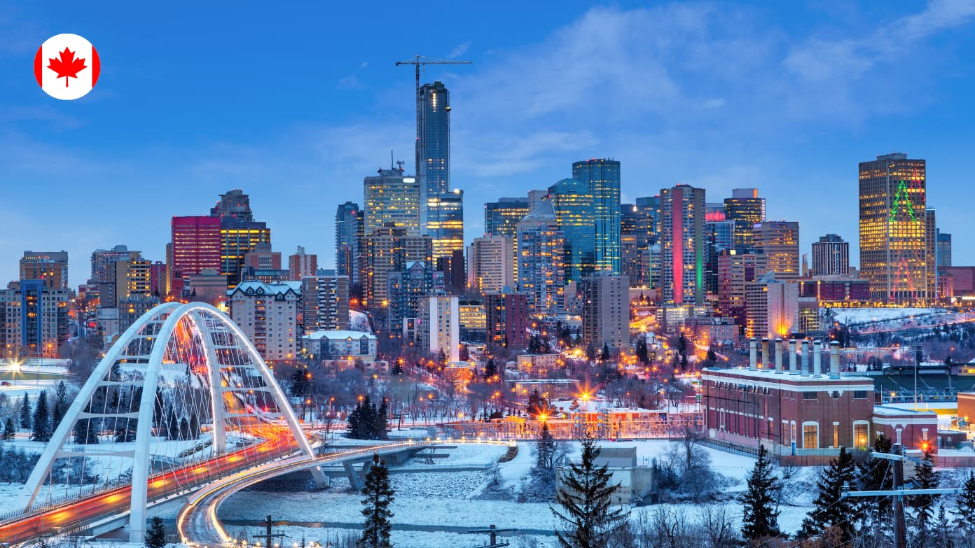 El skyline de la ciudad de Edmonton en invierno al anochecer, con el puente Walterdale iluminado y rascacielos.
